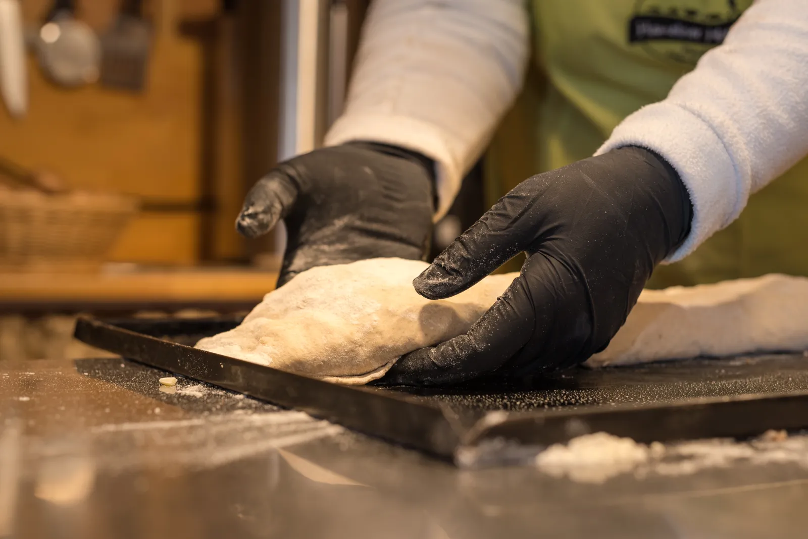 Frisch gebackenes Handbrot wird auf dem Blech geschnitten