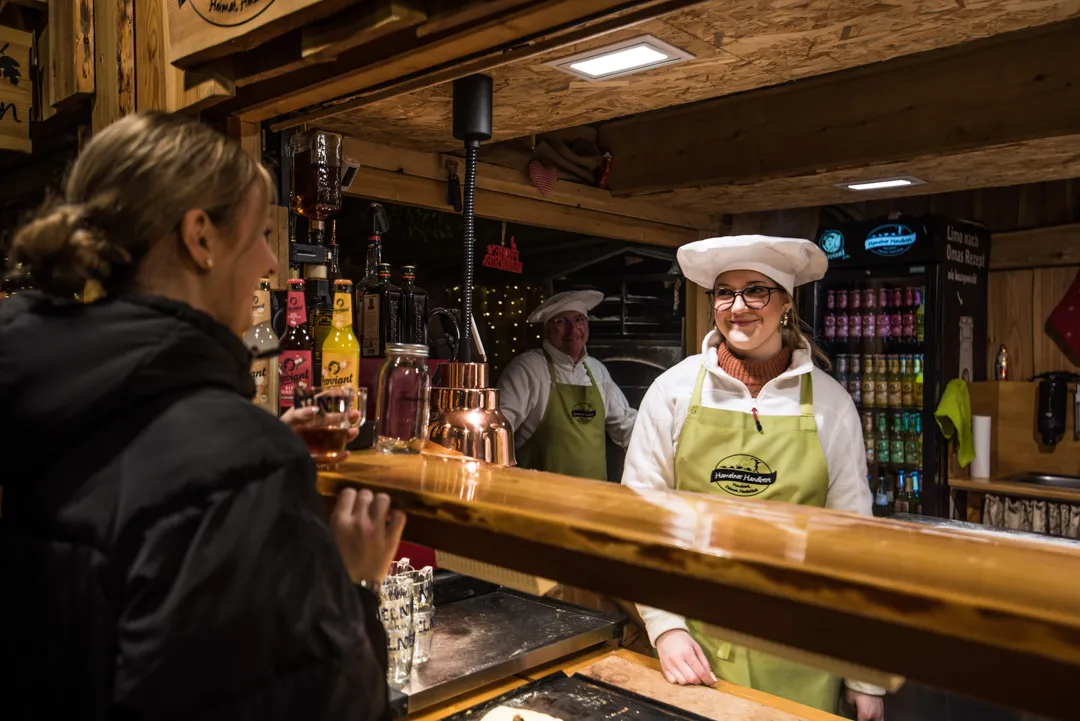 Unsere Bäckerin reicht ein frisches Handbrot über den Tresen