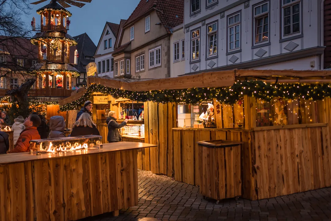 Die Hütten des Hamelner Weihnachtsmarkts am Abend mit der Weihnachtspyramide
