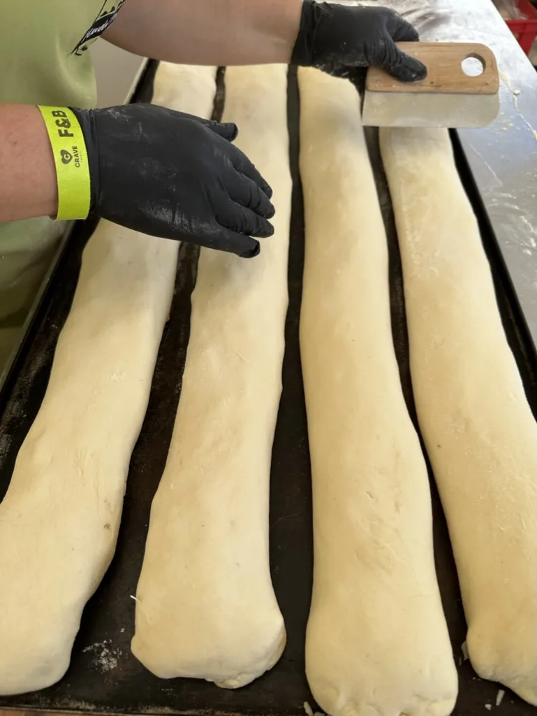 Vier gefüllte Handbrote auf dem Blech, bevor sie in den Ofen kommen